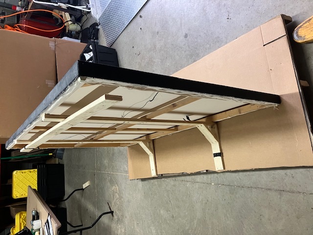 Back of a framed item set into a wood support frame