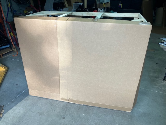 Large wrapped framed piece standing upright in a workspace