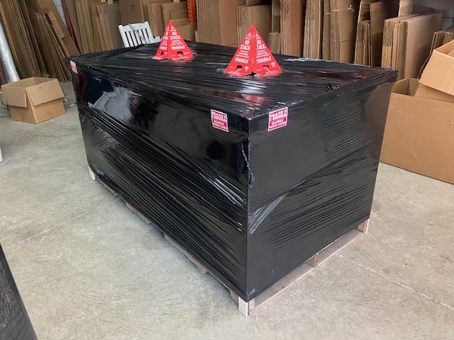 Wrapped rectangular item staged among packing materials