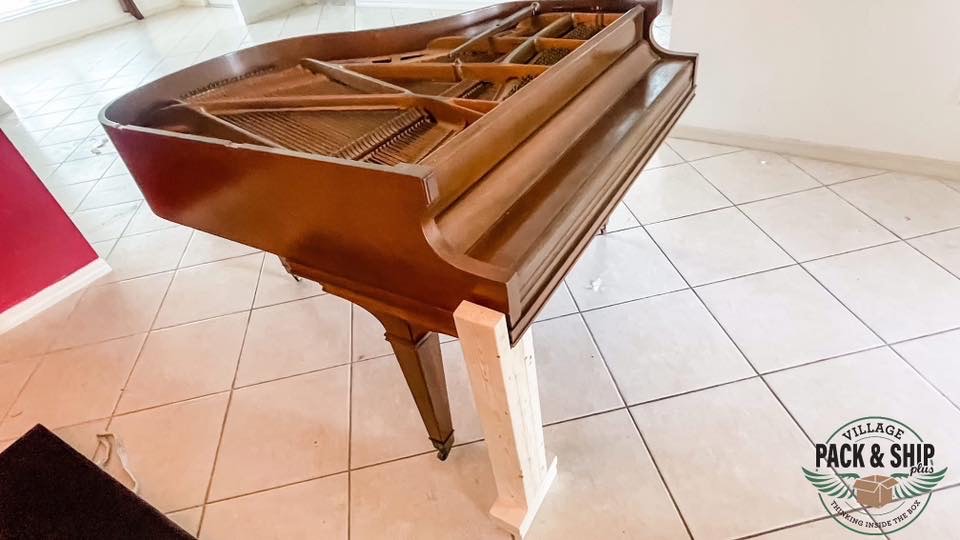 Grand piano in a room before moving preparation