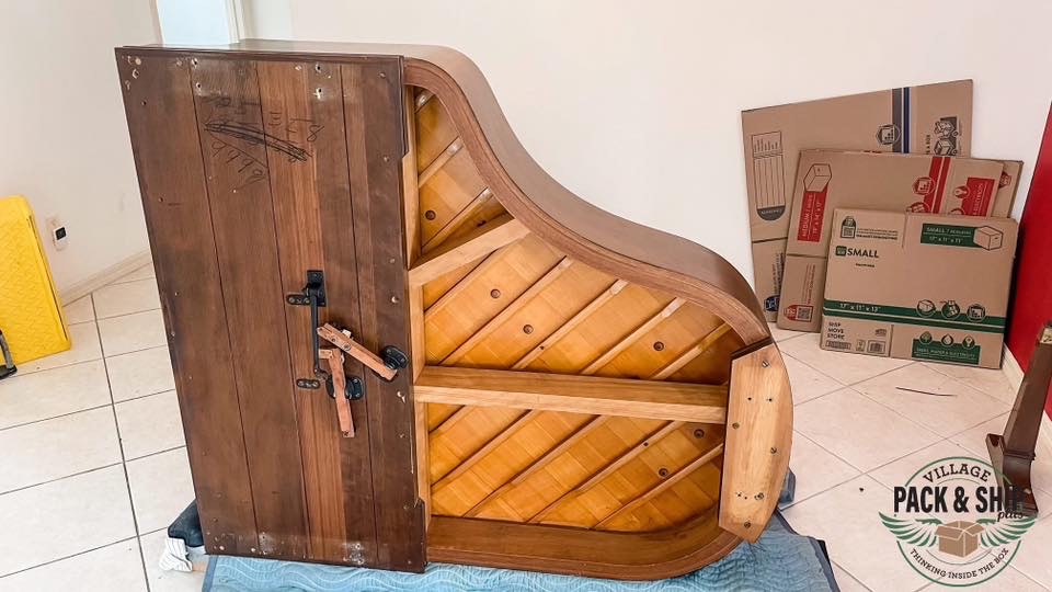 Grand piano positioned on its side with wood supports